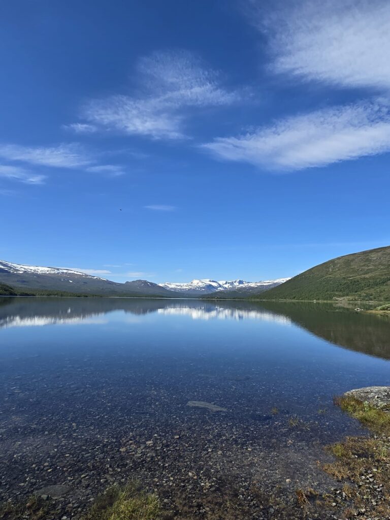 Van Life Europe: Mark, Nikki & Sid’s Journey | Choosing Freedom on the Road 7 Snow capped mountains reflected in lake during van life Europe
