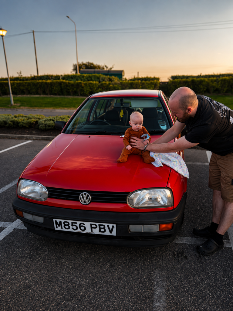 Ben with his daughter beside his red Volkswagen Golf Mk3 Gertrude
