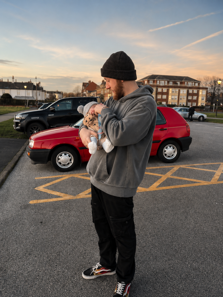 Ben holding his daughter Aubrey beside Gertrude, his red Volkswagen Golf Mk3